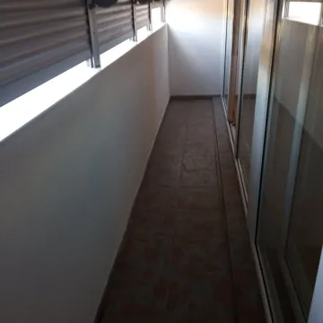 A narrow and long balcony with tiled flooring and sliding glass doors. - image 5