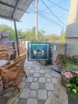 Natkrivena terasa sa garniturom za sedenje i ukrasnim biljem. - image 6