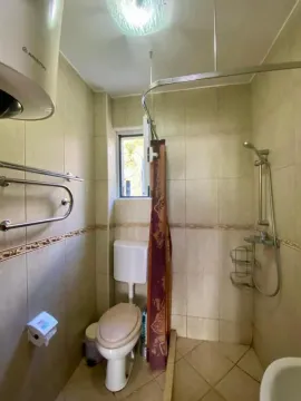 Bathroom equipped with a shower cabin, toilet, and water heater. - image 7