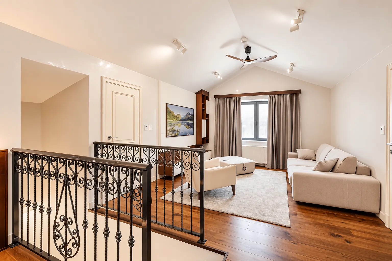 Spacious living room with a sofa set and a metal staircase railing.