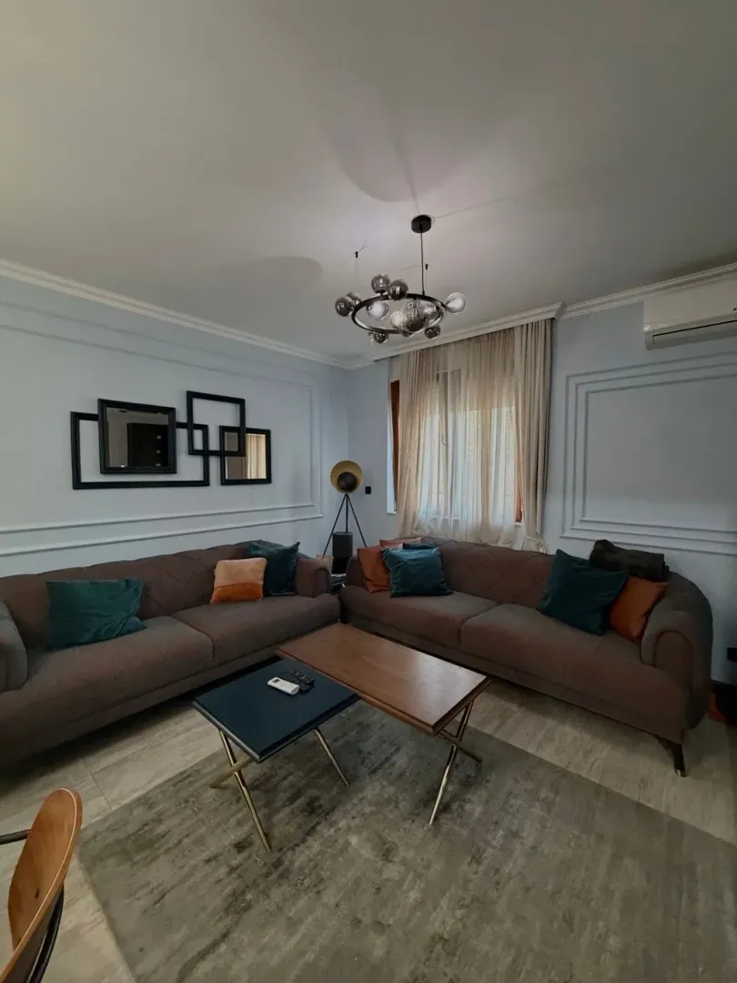 Udobna dnevna soba sa garniturom i modernim osvjetljenjem.