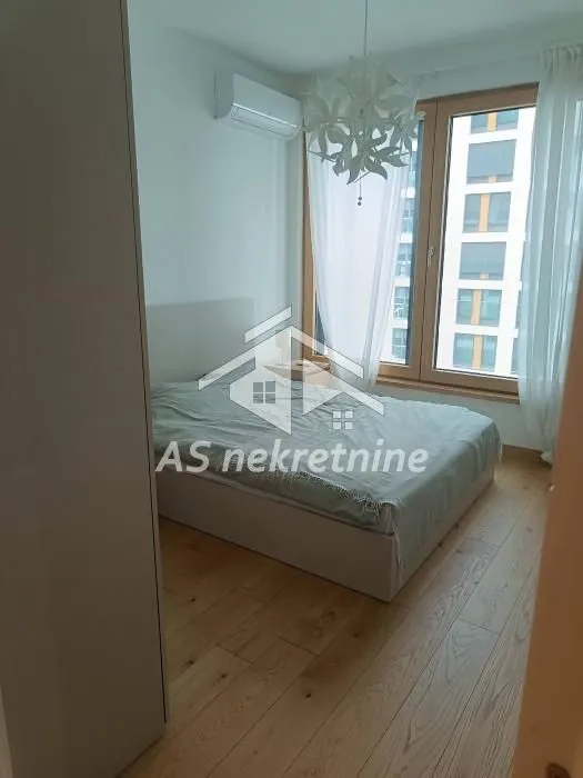 Spavaća soba sa bračnim krevetom, klima-uređajem i velikim prozorom.