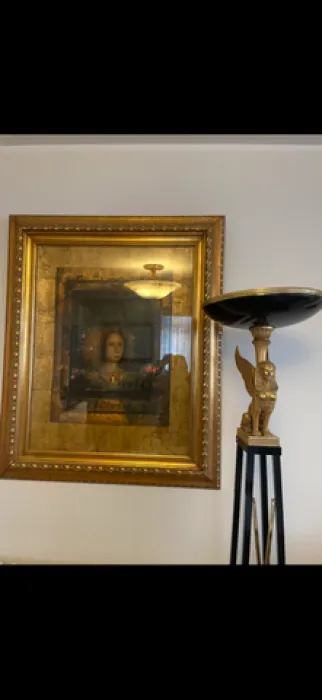 Detalj enterijera sa umetničkom slikom i ukrasnom lampom.