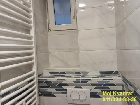 View of the bathroom with white tiles and a built-in radiator. - image 10
