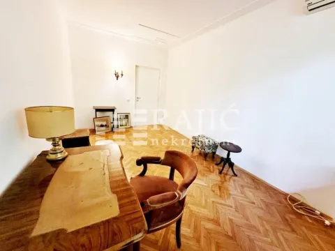 Living room with a desk and parquet flooring. - image 5