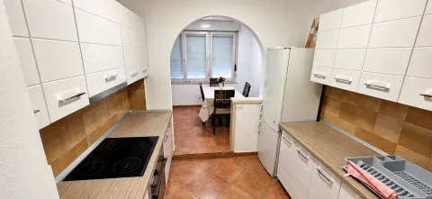 Kuhinja sa bijelim elementima i pogledom na trpezariju kroz luk. - image 3