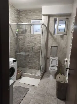 Kupatilo opremljeno tuš kabinom, toaletom i veš mašinom. - image 5