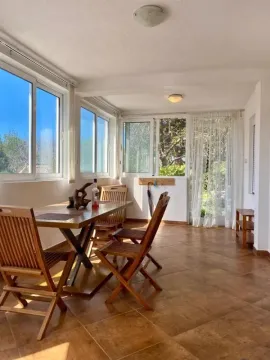Enclosed terrace with a dining table and chairs, and a view of greenery. - image 10