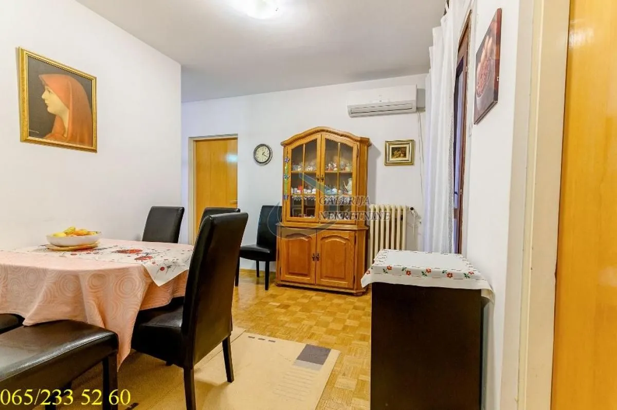 Dining area with a table, chairs, and a wooden cabinet in the apartment.