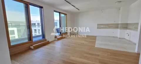 Prostrana prazna dnevna soba sa drvenim podom i velikim balkonskim vratima. - image 3