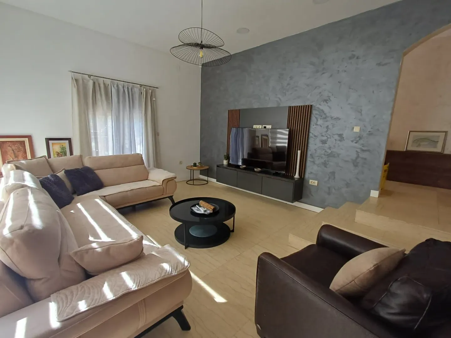Spacious living room with a sofa set and TV unit.