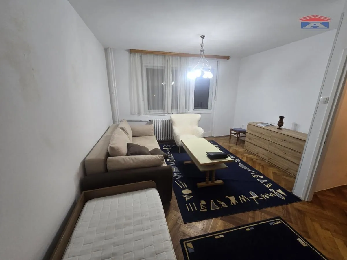 Dnevna soba sa garniturom za sedenje, stočićem i komodom.