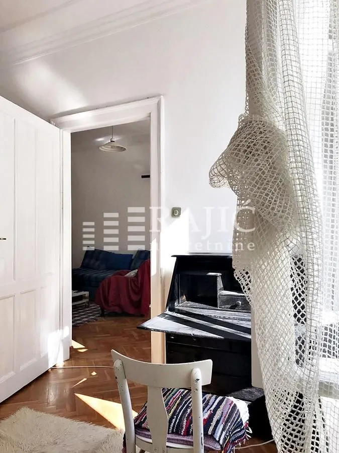 View from the room towards the dining area with a desk and a white chair.