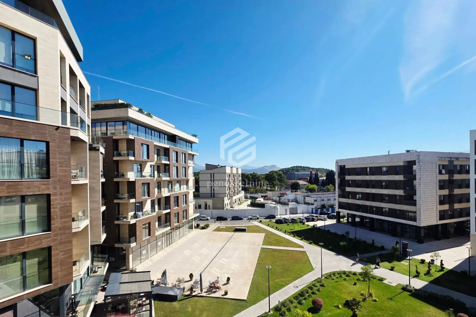 View from the terrace overlooking the landscaped courtyard and surrounding residential buildings.