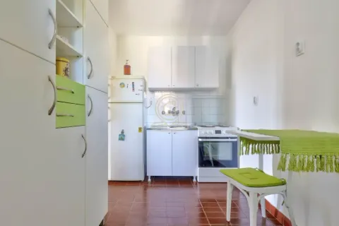 Small white kitchen with a refrigerator, stove, and dining table. - image 13