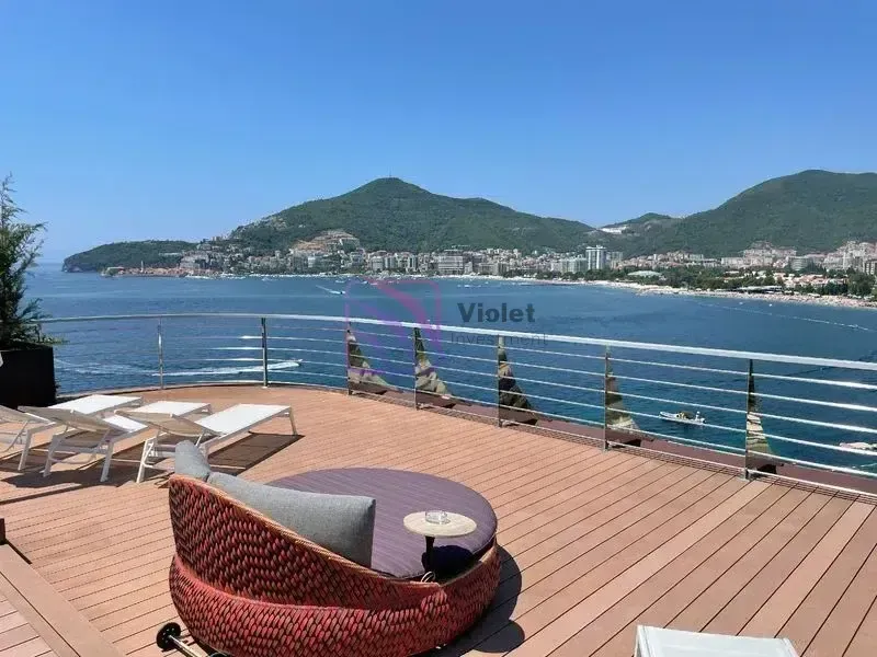 Prostrana terasa sa garniturom za sjedenje i pogledom na more.