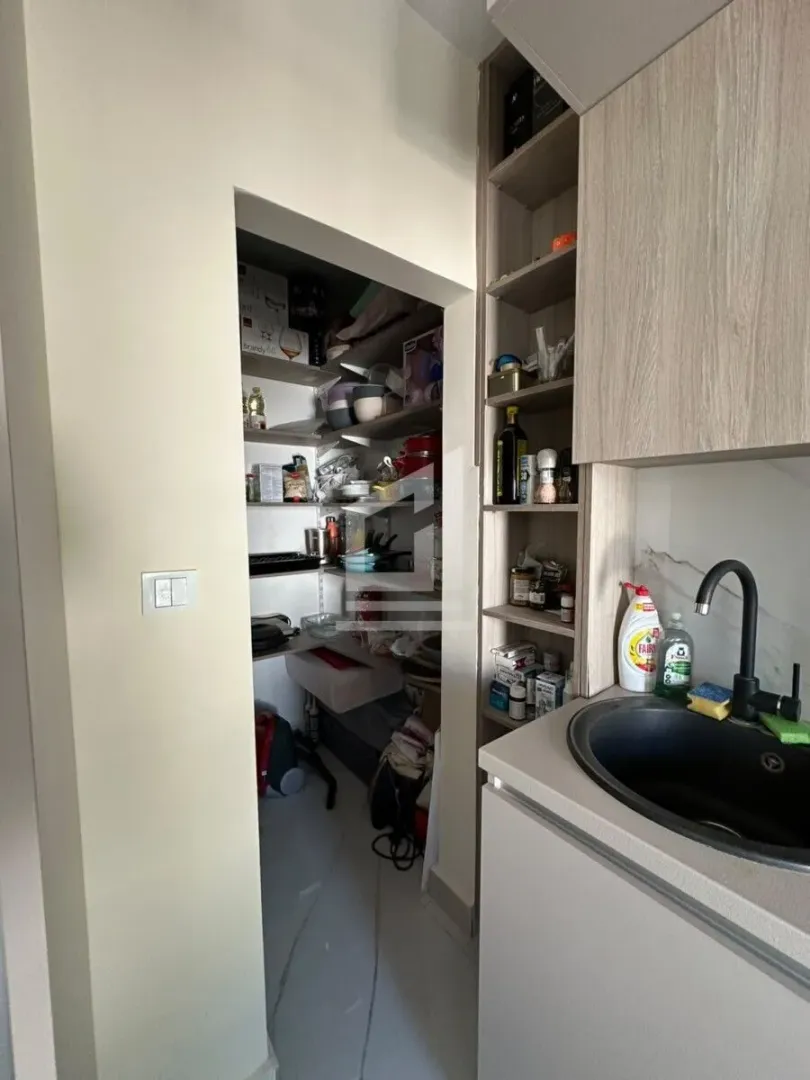 Manja kuhinja sa sudoperom i ostavom u produžetku.