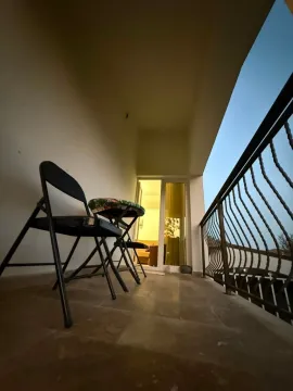 Covered terrace with a small table and chairs, looking outward. - image 10