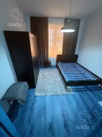 Furnished bedroom with a double bed, wardrobe, and a window.