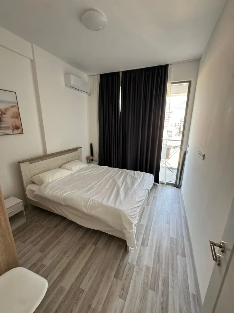 Spavaća soba sa bračnim krevetom, klima uređajem i izlazom na terasu.