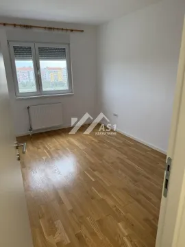 Prazna soba sa parketom i prozorom koji gleda na grad. - image 4