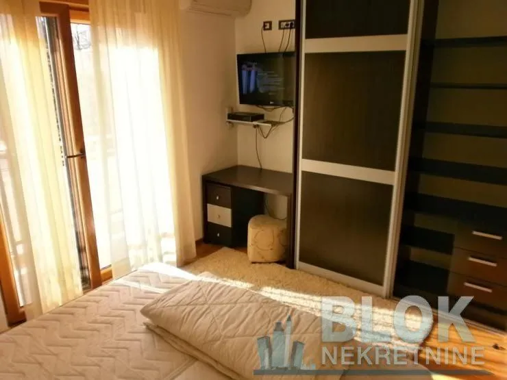 Furnished bedroom with a double bed, wardrobe, and desk.