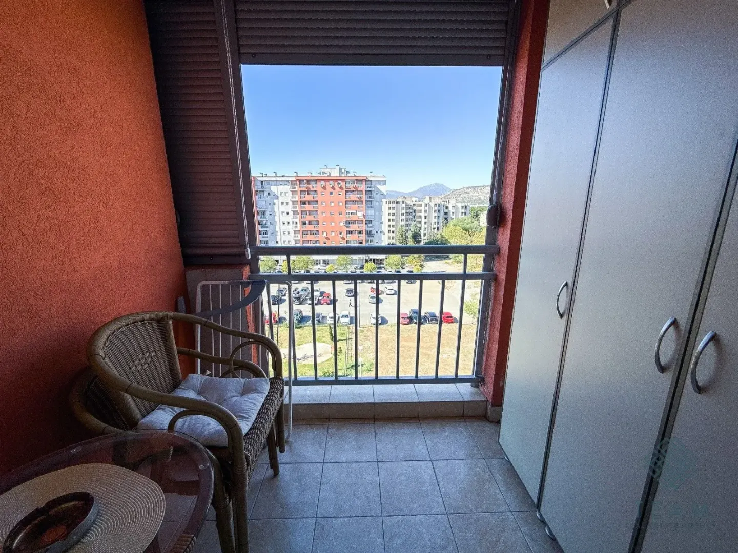Covered balcony with seating furniture and a built-in wardrobe.