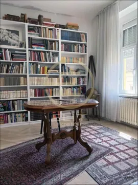 Dnevna soba sa velikom bibliotekom i drvenim stolom. - image 11