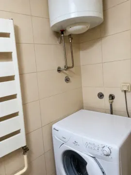 Bathroom with a washing machine, water heater and radiator. - image 4