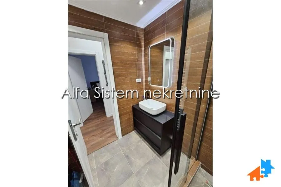 Bathroom with a washbasin, mirror and shower cabin.