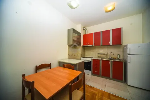 Kitchen with red cabinets and a dining table with four chairs. - image 4