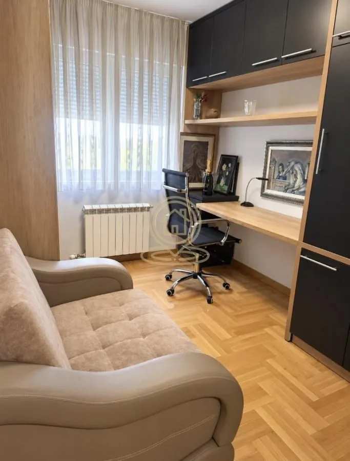 Manja soba sa krevetom, radnim stolom i ugradnim elementima.