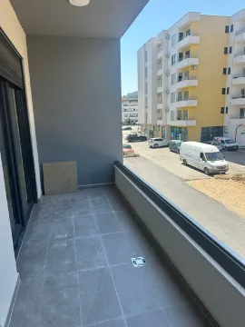 Prostrana popločana terasa sa pogledom na ulicu i okolne zgrade. - image 7