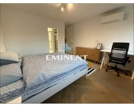 Furnished bedroom with a bed, desk, and air conditioning unit. - image 12