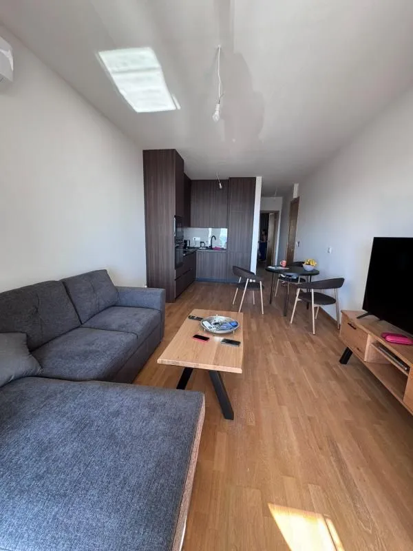 Living room with a sofa, TV, and an adjoining dining area.