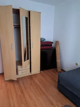 Bedroom with a wooden wardrobe, bed, and chest of drawers. - image 8