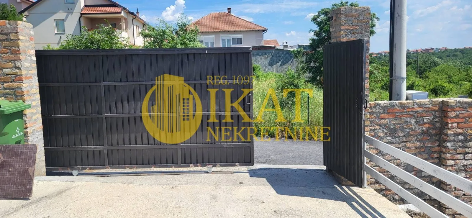 Dvorišna kapija sa ogradom ispred porodične kuće.