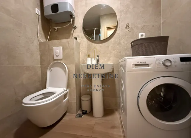 Modernly equipped bathroom with sanitary fixtures and a washing machine.