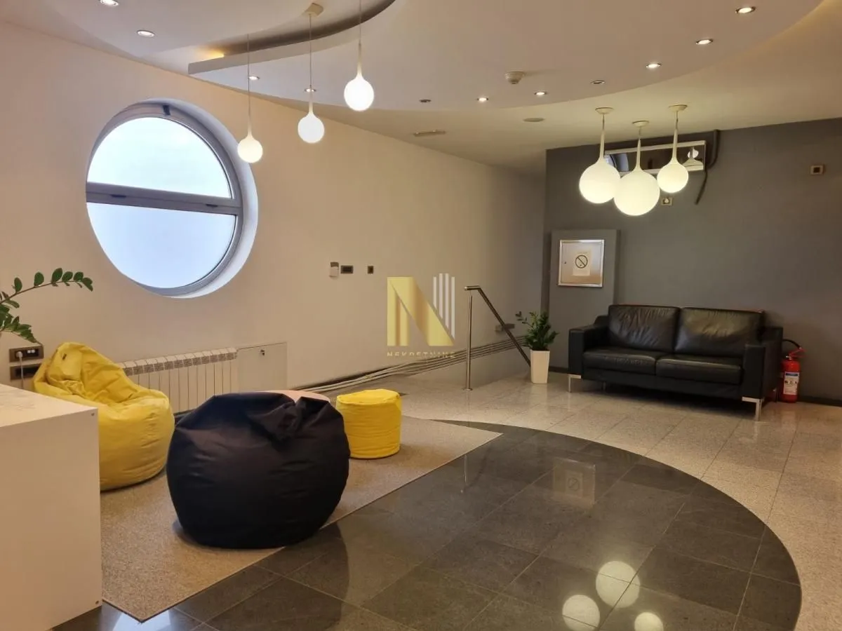 Spacious living room with modern furniture and a round window.