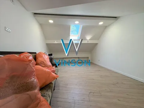 Attic space with wooden flooring and a roof window. - image 3