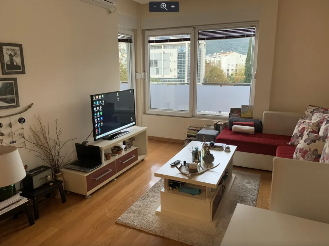 Living room with a sofa, television, and a city view.
