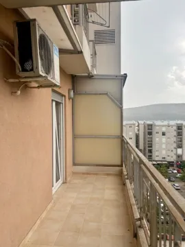 Long balcony with tiled flooring and a view of nearby buildings and surroundings. - image 15