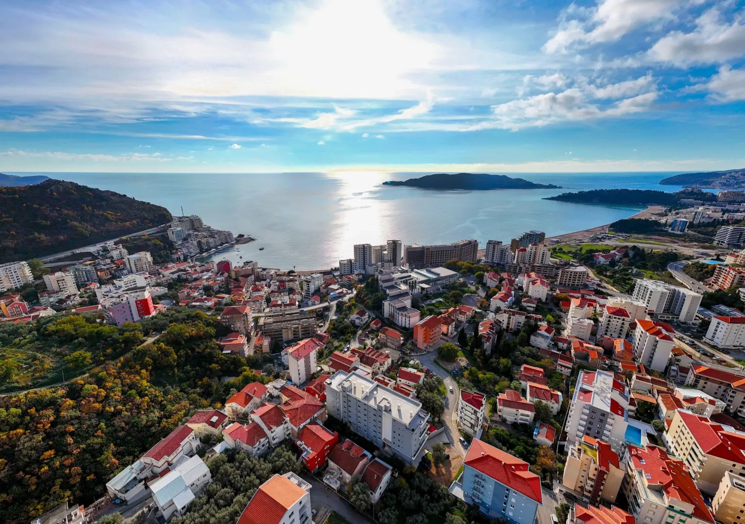 Pogled iz vazduha na obalu i grad sa morem u pozadini.