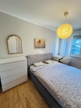 Nameštena spavaća soba sa bračnim krevetom, komodom i ogledalom. - image 7