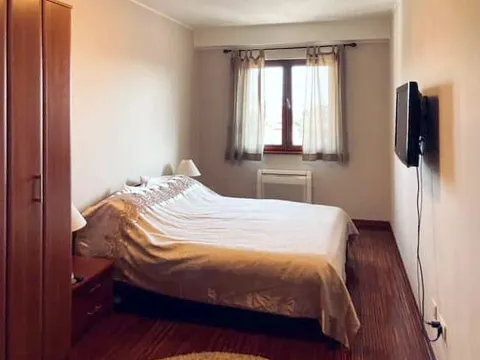 Spavaća soba sa bračnim krevetom, plakarom i televizorom na zidu. - image 5