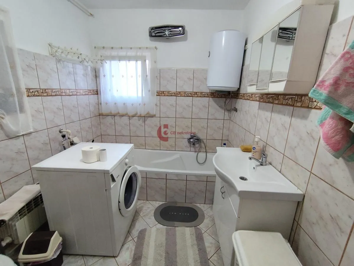 Bathroom equipped with a bathtub, washbasin, washing machine, and water heater.