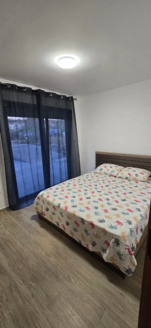 Spavaća soba sa bračnim krevetom i izlazom na terasu.