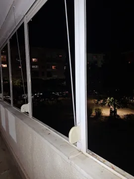 View from the glazed terrace onto the illuminated courtyard and buildings at night. - image 3