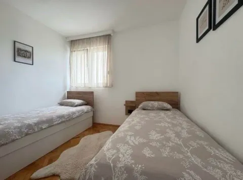 Bedroom with two single beds and a window. - image 2