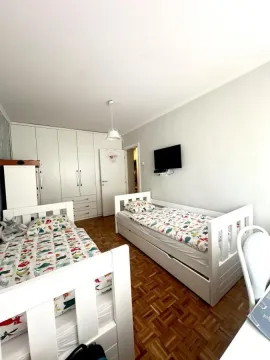 Dečja soba sa dva kreveta, velikim ormanom i televizorom na zidu. - image 10